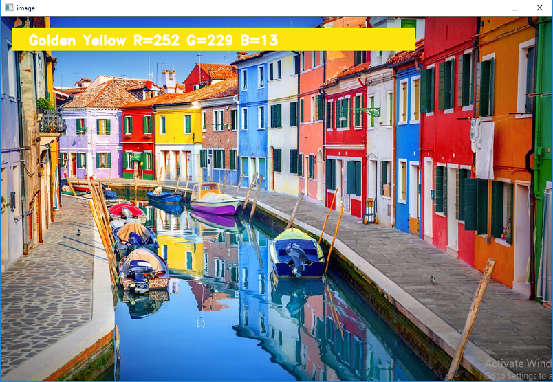 An OpenCV window showing a row of colorful houses with a readout naming the picked color and its RGB values